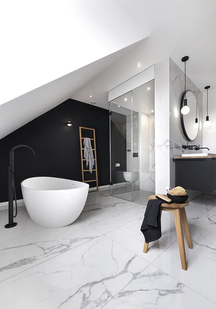 Wellnessbad mit einer freistehenden Badewanne, schwarzen Akzenten und einer Glas-Dampfdusche unter einer Dachschräge.