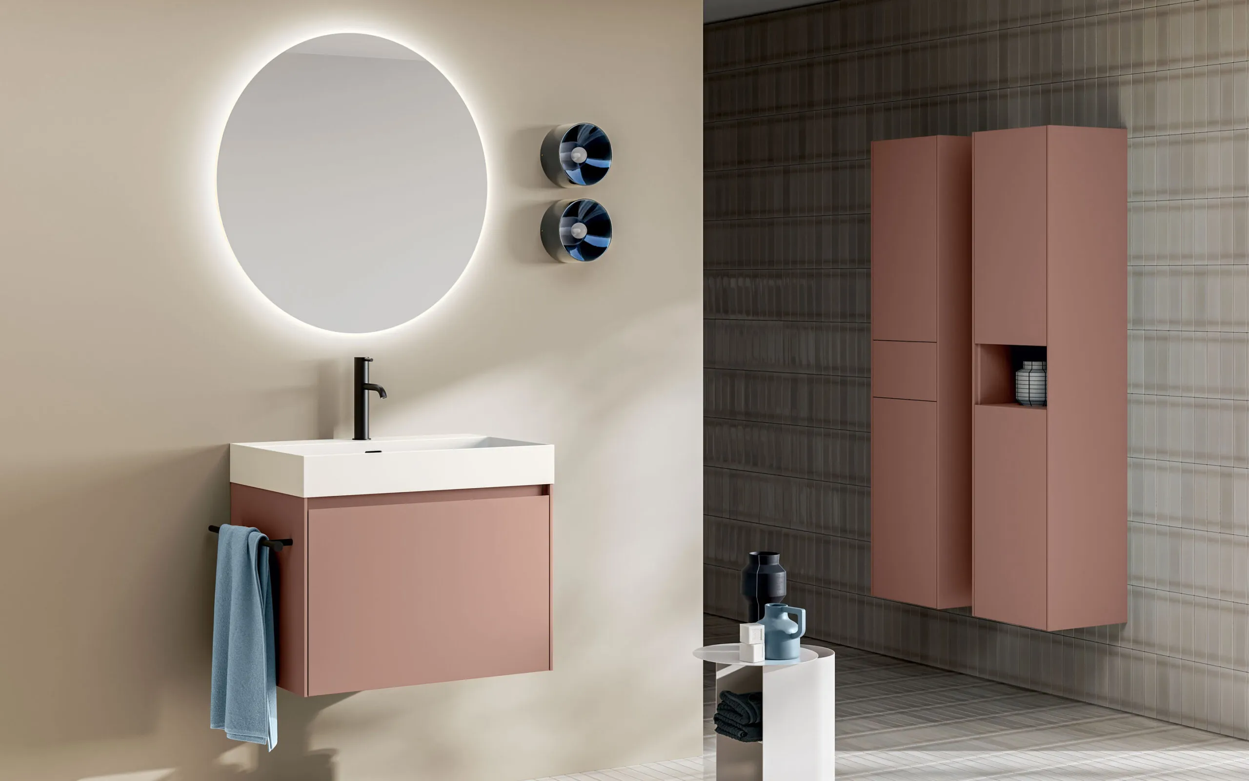 Moderner Waschtisch mit roséfarbener Front, weißem Aufsatzbecken und rundem LED-Spiegel kombiniert mit passendem Hochschrank in zeitloser Badgestaltung von Stocco.