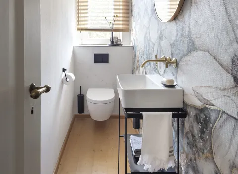 Schmales, schlauchförmiges Gästebad mit Fenster an Stirnseite. Unterhalb des Fensters ist ein wandhängendes WC angebracht.