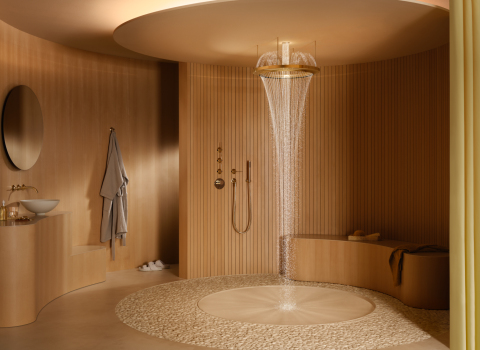 Ein luxuriöses Badezimmer mit einer goldenen Regendusche, aus der Wasser in einem feinen Strahl fällt.