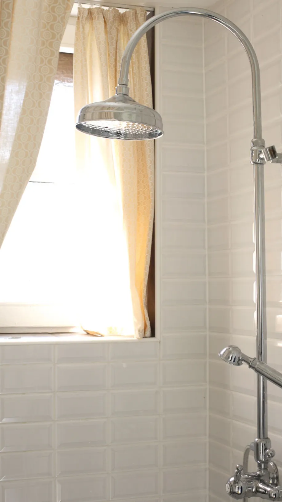 Dusche mit Fensterblick und weißen Fliesen.