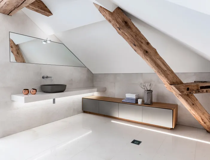 Ein helles Badezimmer mit Holzbalken.
