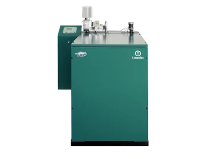 Ein Blockheizkraftwerk in grünem Gehäuse von SenerTec mit einem stilisierten Dachssymbol auf der Vorderseite.