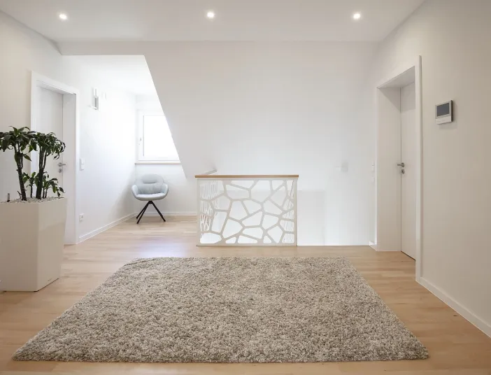 Helles, modern eingerichtetes Zimmer mit schlichtem Dekor und viel natürlichem Licht.