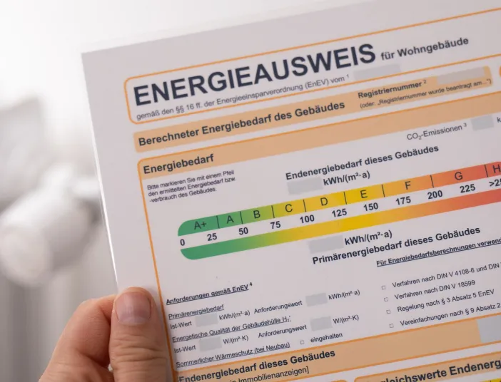 Eine Hand hält einen Energieausweis.