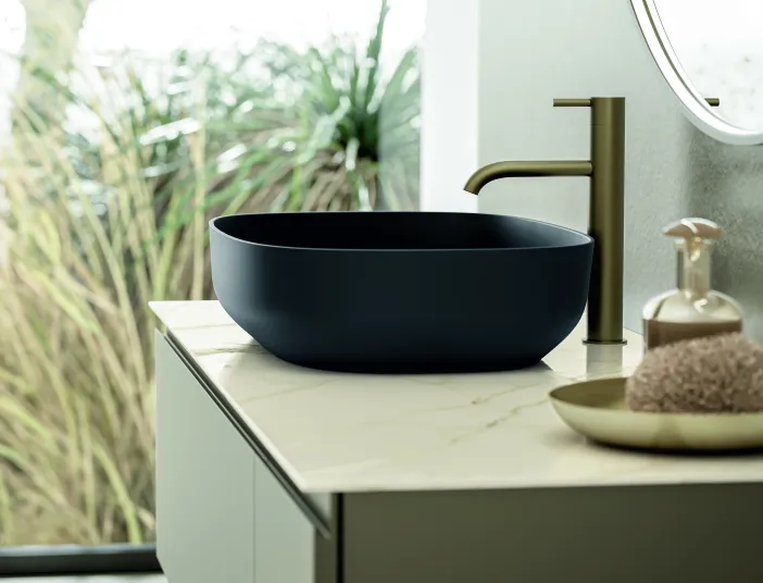 Stocco Over G mit schwarzem Waschbecken und goldener Armatur.